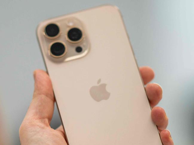 A person holds up a new iPhone 16 Pro following Apple's "It's Glowtime" event in Cupertino, California, September 9, 2024. (Photo by Nic COURY / AFP)