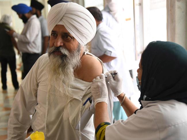 A medical worker inoculates a man with a dose of the of the Covid-19 coronavirus vaccine, at the Golden Temple in Amritsar. Picture: AFP