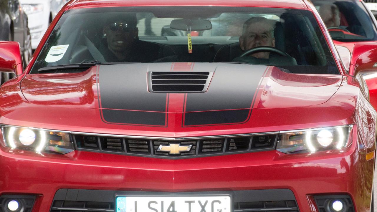 French footballer Paul Pogba (L) arrives in a convoy of vehicles at Manchester United's Carrington training complex, in Manchester, north west England on August 8, 2016. France midfielder Paul Pogba arrived in Manchester on August 8 to complete his record-breaking transfer to Manchester United from Juventus, British media reported. Sky Sports News said the 23-year-old had flown to Manchester from Nice in a private jet and would undergo a medical at United's Training Complex. / AFP PHOTO / OLI SCARFF