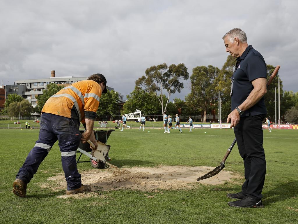 Ground staff at Victoria Park use sand to cover a leak on Sunday. Picture: Dylan Burns/AFL Photos via Getty Images.