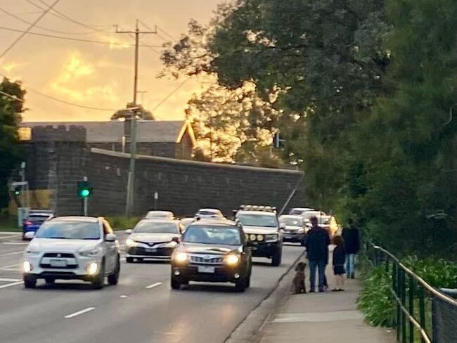 A family walks next to Murray Rd showing how close traffic gets to the footpath.