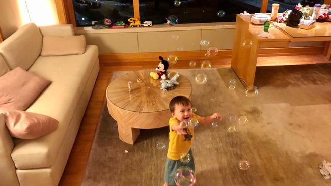 Joy Van Dee's toddler chases bubbles while quarantined in their government-assigned space at the Ritz-Carlton Millenia Singapore. Picture: Joy Van Dee via The Wall Street Journal