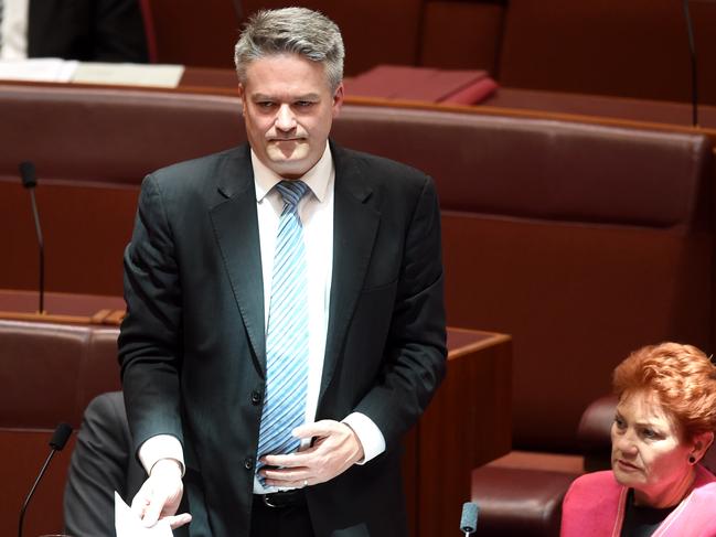 Australian Minister for Finance Matthias Cormann and One Nation Party leader Senator Pauline Hanson react after a division on the proposed backpacker tax in the Senate chamber at Parliament House in Canberra, Thursday, Nov. 24, 2016. (AAP Image/Lukas Coch) NO ARCHIVING