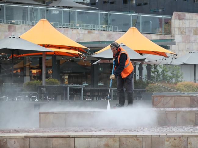 A cleaner clears rubbish at Federation square. Picture: David Crosling