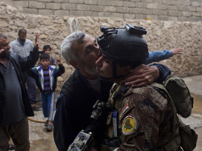 A man kisses an Iraqi special forces soldier after his house was searched, in Gogjali, an eastern district of Mosul, Iraq. Picture: Marko Drobnjakovic.