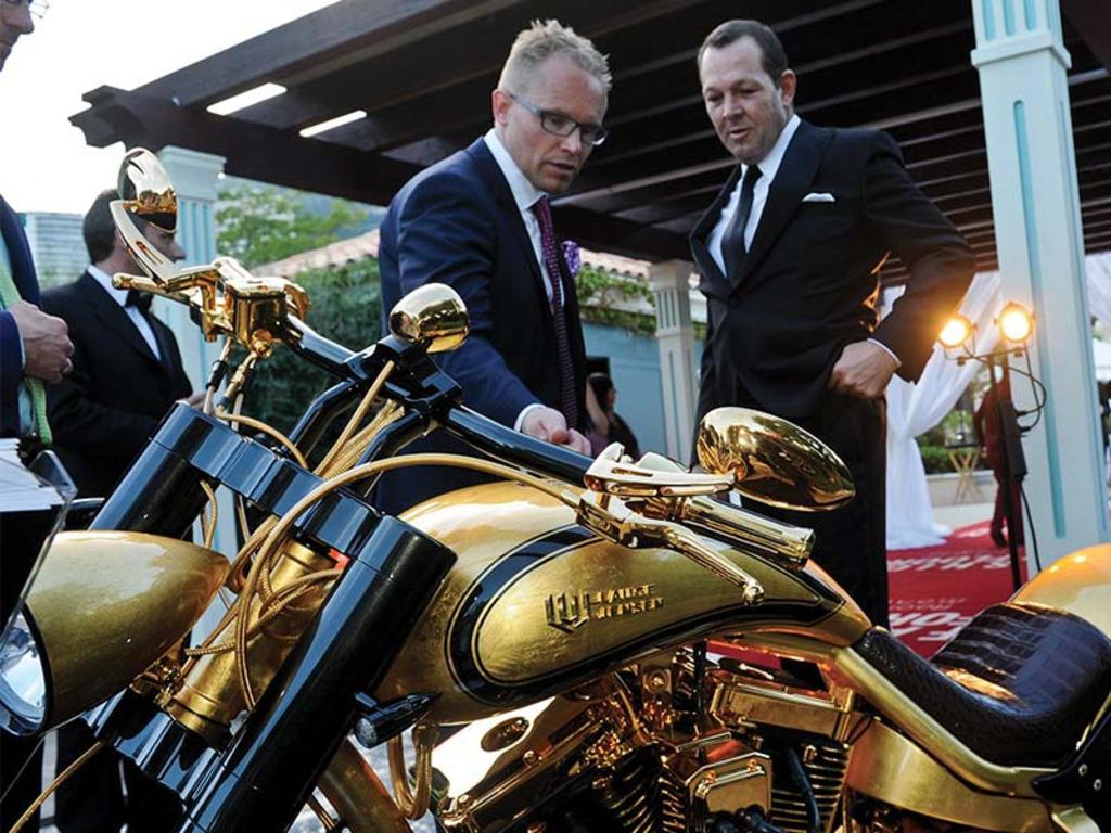 Jeff McGlinn (right) examines a golden motorbike. Picture: Supplied