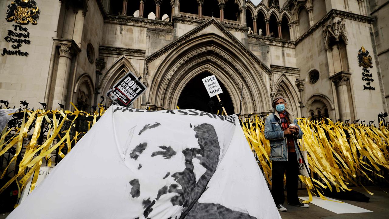 Protesters display a banner with an image of WikiLeaks founder Julian Assange during a demonstration outside the Royal Courts of Justice. Picture: AFP.