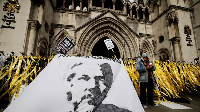 Protesters display a banner with an image of WikiLeaks founder Julian Assange during a demonstration outside the Royal Courts of Justice. Picture: AFP.