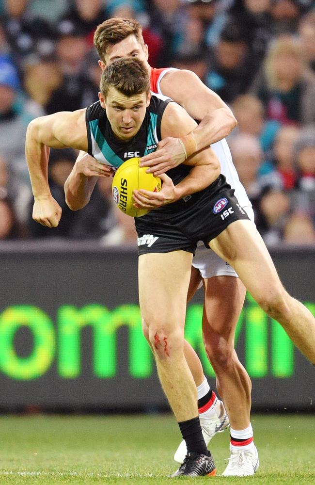 Jack Trengove tries to dish out a handball under pressure from St Kilda’s Jack Steele.