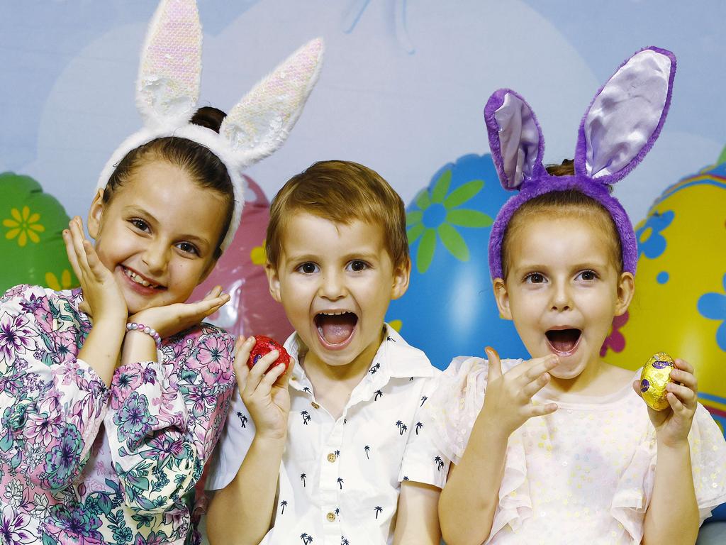 The Easter Bunny is visiting DFO Cairns these school holidays, posing for photos and giving away Easter eggs. Marli Rees, 7, Loxley Rees, 4, and Kennedy Rees, 5, enjoy eating some Easter eggs given to them by the Easter bunny. Picture: Brendan Radke