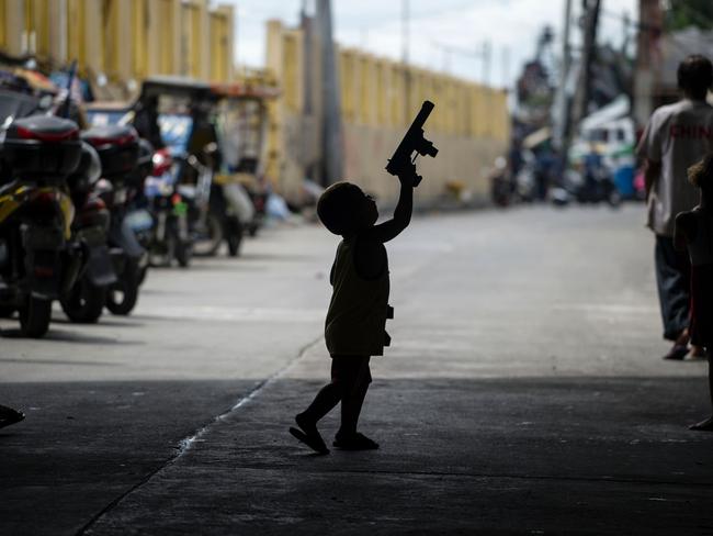 A child plays with a toy gun in a community in Manila. The Philippines has one of the highest rates of gun ownership in South East Asia. Picture: AFP/ Noel Celis