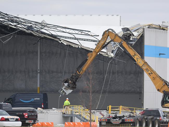 Construction crews work to clear wreckage from a damaged Amazon Distribution Centre after it was struck by a tornado, killing two and trapping dozens inside. Picture: AFP