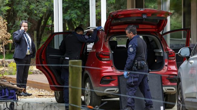 Police showed particular interest in a red car. Picture: NCA newsWire / Ian Currie