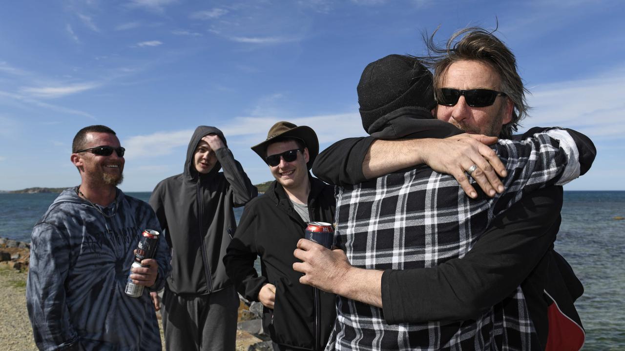 Matt Bentley, and Derek's sons Tim and Ashley Robinson, watch as Ian Robinson embraces his brother Derek Robinson (right) as he disembarks a police boat at Encounter Bay. Picture: NCA NewsWire / Naomi Jellicoe