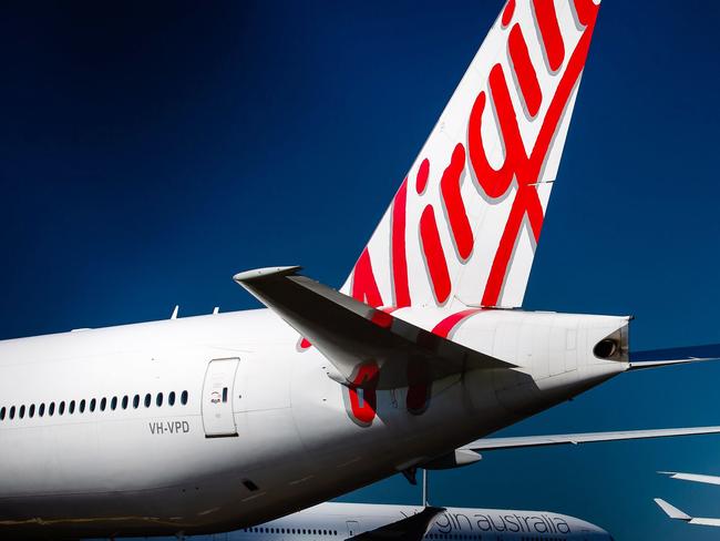 Virgin Australia aircraft are seen parked on the tarmac at Brisbane International airport on April 21, 2020. - Cash-strapped Virgin Australia collapsed on April 21, making it the largest carrier yet to buckle under the strain of the coronavirus pandemic, which has ravaged the global airline industry. (Photo by Patrick HAMILTON / AFP)