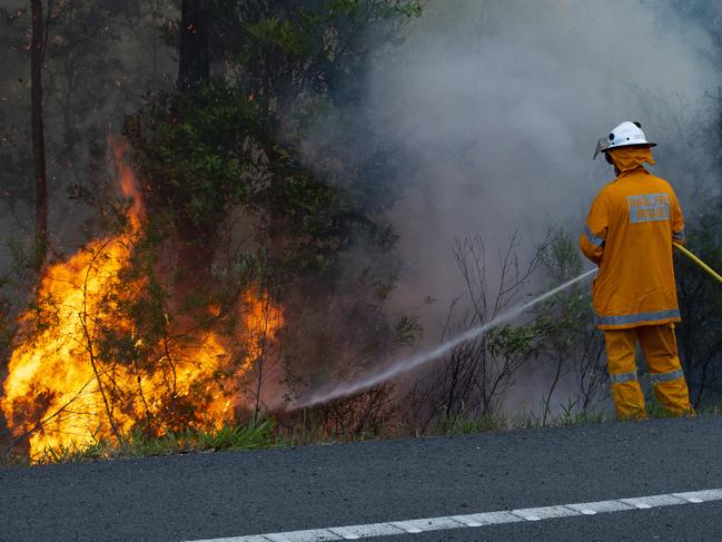 Rural firefighters work to control a blaze near the Sunshine Coast motorway that threatened a number of homes near Peregian Springs and forced residents to evacuate near Lake Weyba.  Photo Lachie Millard