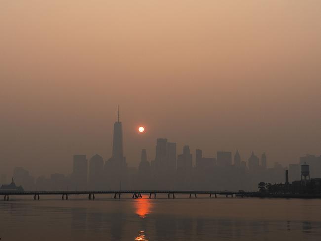 The sun rises behind The One World Trade Center and the New York skyline, while the smoke from Canada wildfires covers Manhattan. Picture: AFP