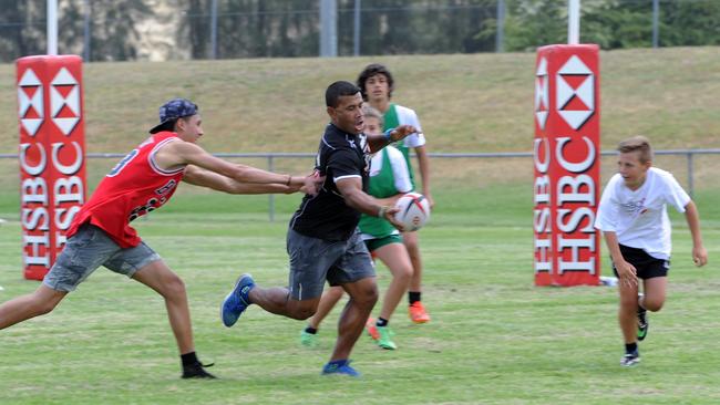 Waisale Serevi (centre) plays a game with kids at the rugby festival.