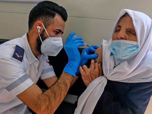 A paramedic with Israel's Magen David Adom medical services vaccinates a Palestinian woman in a mobile clinic at the Damascus Gate in Jerusalem's Old City. Picture: Ahmad Gharabli/AFP