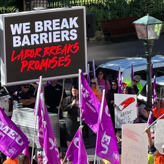 State Development Minister Grace Grace addresses a CFMEU event next to an unfortunate sign.