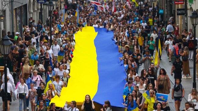 People hold a huge Ukrainian flag while attending a march on the Independence Day of Ukraine in Krakow, Poland on Wednesday. Picture: Beata Zawrzel/NurPhoto via Getty Images.