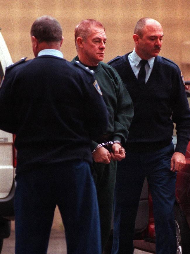 John Killick heads to court in handcuffs in 1999 after his most infamous escape by hijacked helicopter. Picture: Bill Counsell