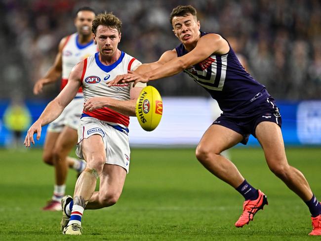 Cooper Simpson tries to smother a kick from Lachie Bramble. Picture: Daniel Carson/AFL Photos via Getty Images