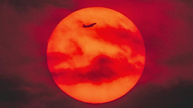 A plane flies past a fiery sunset over Ulladulla on the NSW South Coast. Picture: Gary Ramage