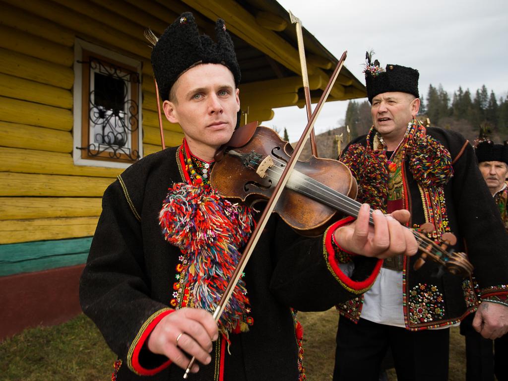 In Iltsi, Ukraine, men wear traditional Hutsul clothing after Christmas mass to march and carol around the church before travelling house-to-house into the night. The carolling takes 12 days until they have visited every home in the village. Picture: Getty