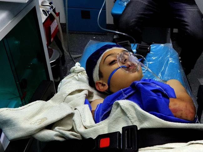 A wounded pupil lays on a stretcher at a hospital after a bus accident near the Dead Sea in Jordan on October 25, 2018. - Flash floods in Jordan swept away a school bus on October 25, killing at least 17 people, mostly pupils, emergency services said, as Israel sent forces to help with rescue operations. (Photo by Khalil MAZRAAWI / AFP)