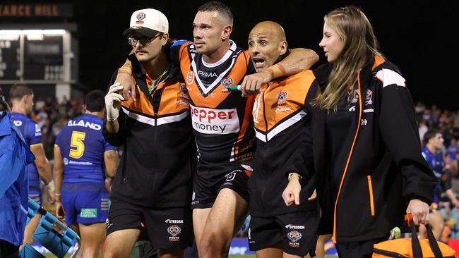 SYDNEY, AUSTRALIA - FEBRUARY 21:  Brent Naden of the Wests Tigers is assisted off the field after a knee injury during the 2025 NRL Pre-Season Challenge match between Wests Tigers and Parramatta Eels at Leichhardt Oval on February 21, 2025 in Sydney, Australia. (Photo by Mark Metcalfe/Getty Images)