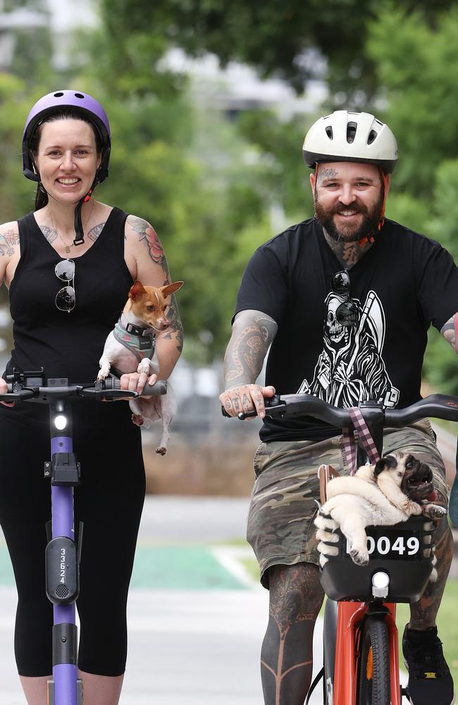 Annerley resident Lauren Whelan, 33, with Billie on an electric scooter and Justin Kannenberg, 37, with Franklin on an electric bike, South Bank. Picture: Liam Kidston.