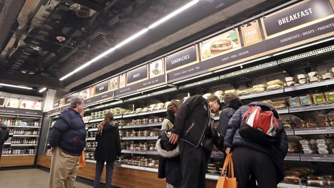 Sensors and cameras, part of a system used to tell what people have purchased, are attached overhead as shoppers walk in an Amazon Go store. Picture: AP.