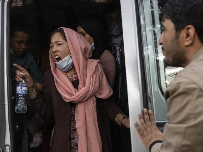 KABUL, AFGHANISTAN - AUGUST 12:  A woman yells for her family to hurry up as displaced Afghans from the northern provinces are evacuated from a makeshift IDP camp in Share-e-Naw park to various mosques and schools on August 12, 2021 in Kabul, Afghanistan. People displaced by the Taliban advancing are flooding into the Kabul capital to escape the Taliban takeover of their provinces. (Photo by Paula Bronstein/Getty Images)