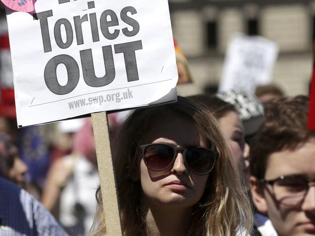 People demonstrate in Parliament Square against the possible Conservative and DUP (Democratic Unionist Party) coalition government following the Britain's general election result, in London, Saturday June 10, 2017. Beleaguered British Prime Minister Theresa May was working to fill out the ranks of her minority government Saturday after an election that proved disastrous for her Conservative Party and complicating for Britain's exit from the European Union.  (AP Photo/Tim Ireland)