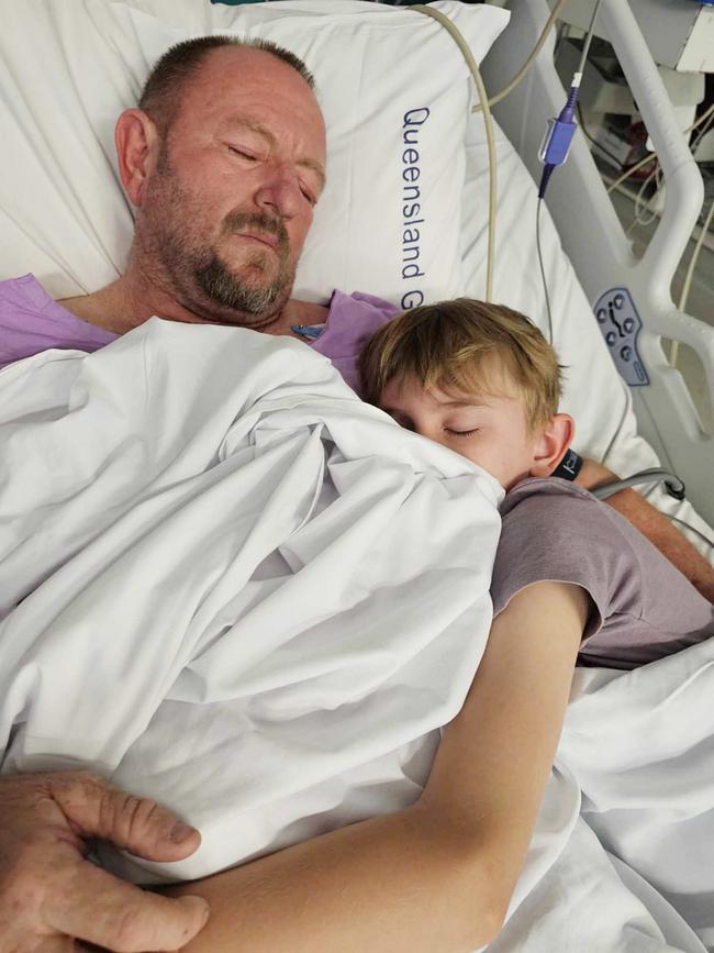 Snake catcher Tony Harrison in hospital after he was bitten by an eastern brown, pictured with son Jensen. Photo: Supplied.