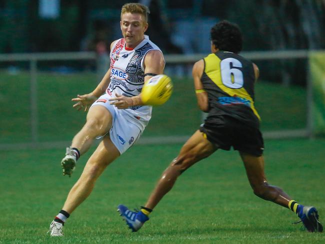 Southern Districts’ Matthew Duffy kicks to a teammate with Nightcliff’s Liam Holt-Fitz fast approaching. Picture: Glenn Campbell