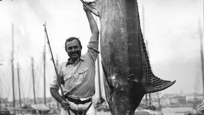 Ernest Hemingway posing with a marlin.