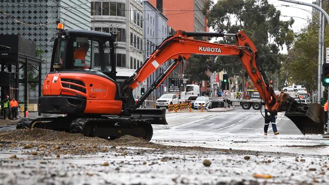 An excavator clears mud after a burst water pipe flooded Victoria Street in Melbourne. Picture: Erik Anderson/AAP