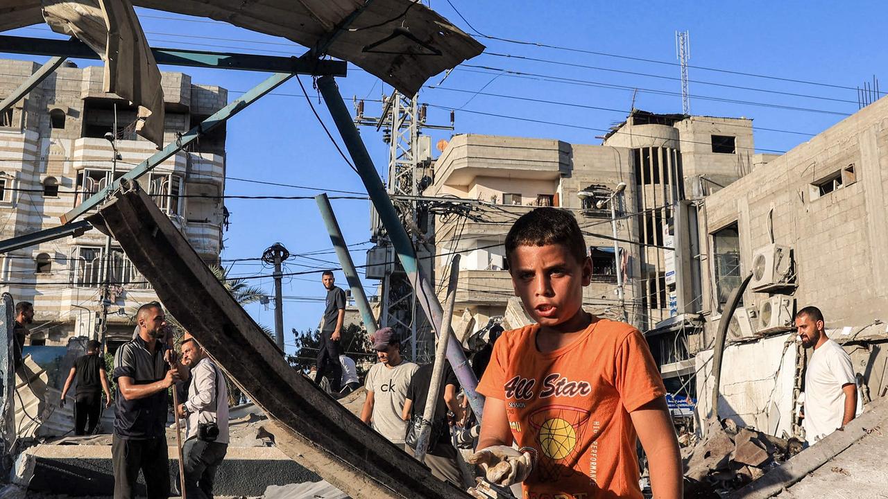 A boy inspects the rubble of a collapsed building in the aftermath of Israeli bombardment at the Jaouni school run by the UN Relief and Works Agency for Palestine Refugees (UNRWA). Picture: AFP