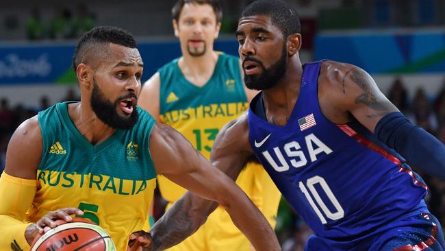 Australia's guard Patty Mills (L) tries to pass USA's guard Kyrie Irving during a Men's round Group A basketball match between Australia and USA at the Carioca Arena 1 in Rio de Janeiro on August 10, 2016 during the Rio 2016 Olympic Games. / AFP PHOTO / Andrej ISAKOVIC