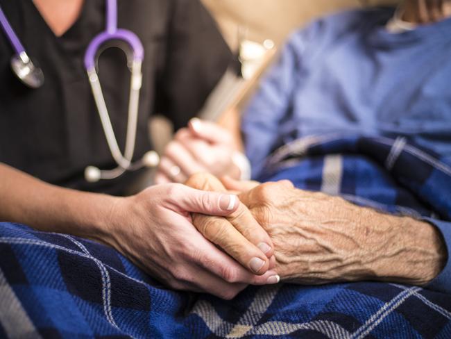 A stock photo of a Hospice Nurse visiting an Elderly male patient who is receiving hospice/palliative care.