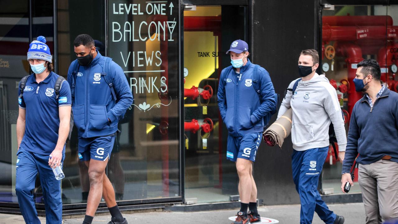 Geelong players leave their hotel on Friday morning after being stranded in Adelaide.