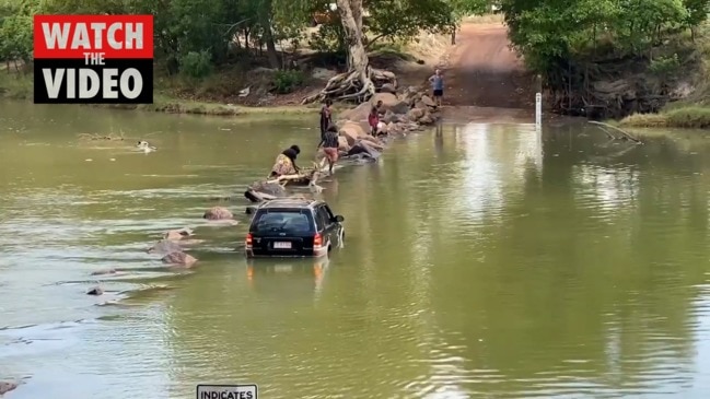 Heart-stopping moment people walk through Cahills Crossing after flooding their car