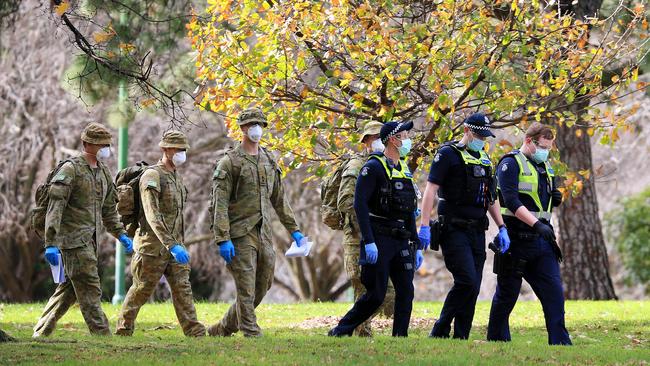 Victoria Police and members of the ADF patrol the popular running track around Melbourne's Botanical Gardens. Picture: Mark Stewart