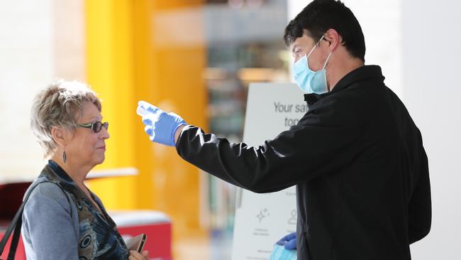 .Apple store workers check temperatures of customers at the CBD shop today. Picture: Tait Schmaal