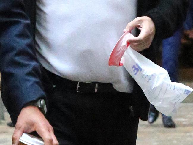 Clive Palmer holds his sick bag at court.