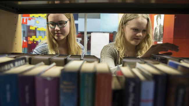 Vilma, 14, and Lotta, 15 pick up books at the Hiidenkiven Pereskoulu School library in suburban Helsinki. Picture: Ella Pellegrini.