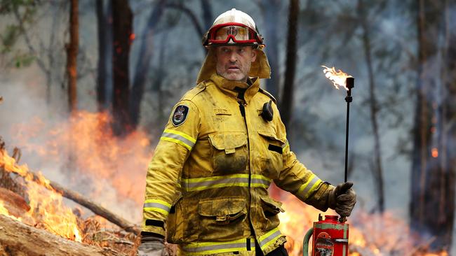 A Rural Fire Service volunteer carries out controlled burns near the village of Spencer on the Hawkesbury River. Picture: Jane Dempster