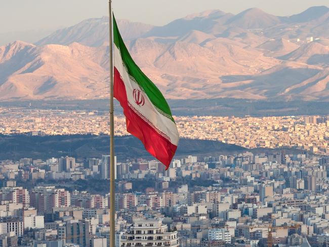 Waving Iran flag above skyline of Tehran at sunset.Photo - istockEscape 20 Oct 2024